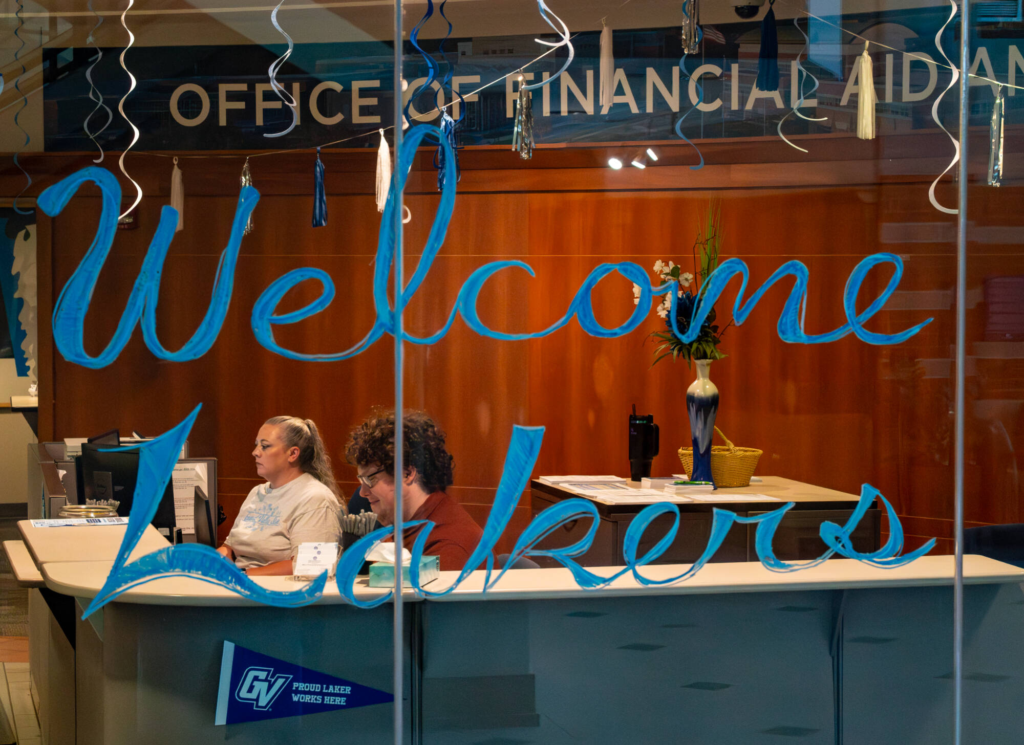 Financial Aid Assistant Erin Braginton and Financial Aid Graduate Assistant Steven Lawrence work inside the Office of Financial Aid and Scholarships at Lubbers Student Services Center on August 13. (Photo releases on file)